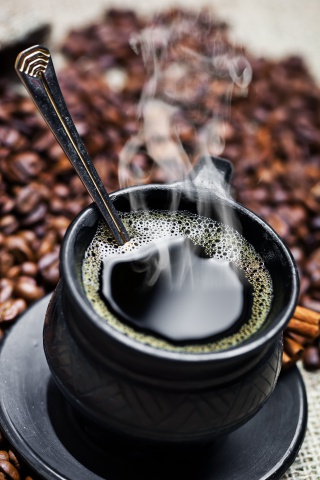 盛满咖啡的黑色咖啡杯图片