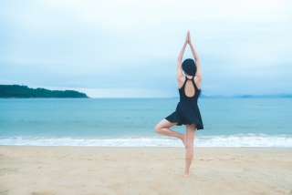 沙滩上进行瑜伽的少女